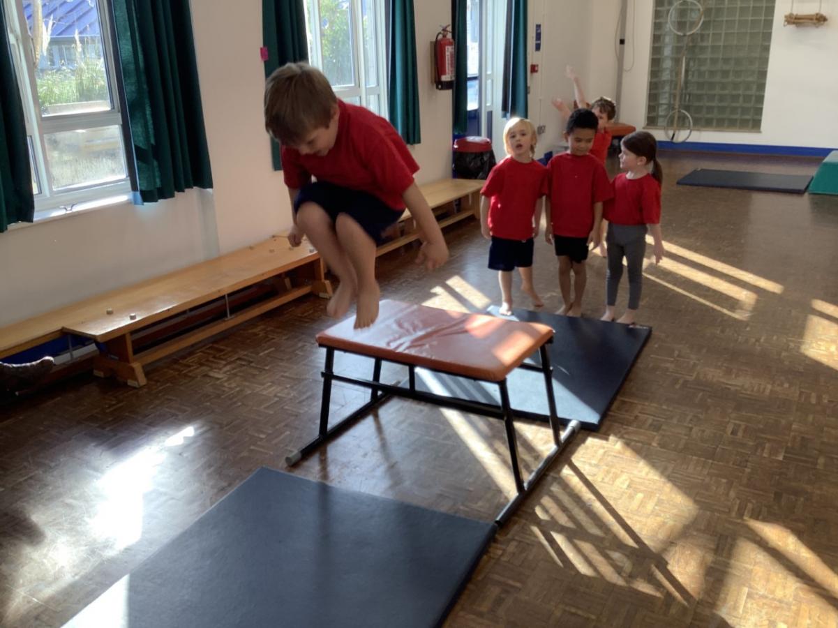 children jumping over a bench in P.E.